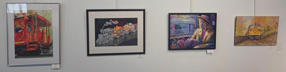 Four framed train artworks — caboose, locomotive with fruit, woman at station, and train in autumn